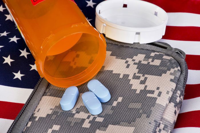 How Drug and Alcohol Abuse Affects the Veteran Community - pill bottle on camo pouch on usa flag