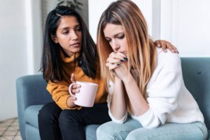 young woman consoling her friend - hydrocodone addiction