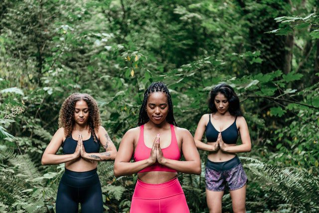 Grounding Techniques to Use in Recovery, Grounding Techniques - Photo by PNW Production: https://www.pexels.com/photo/women-wearing-sports-bra-meditating-in-the-woods-8980969/